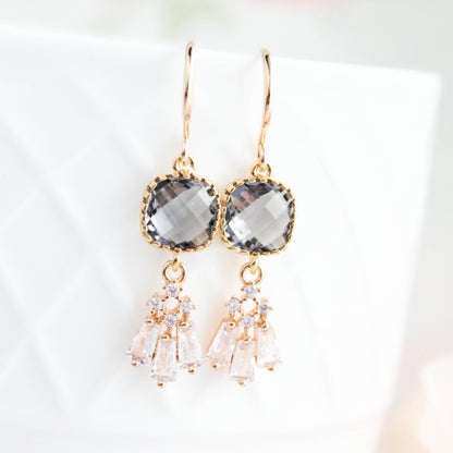 Gold earrings with gray gemstones on a light background