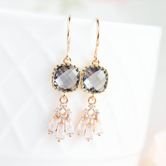 Gold earrings with gray gemstones on a light background