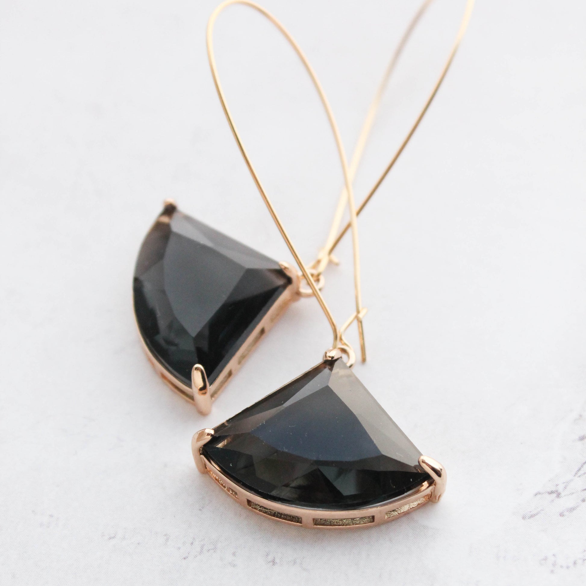 A pair of art deco fan shaped black glass dangle earrings with gold plating and a nickel free wire hooks.